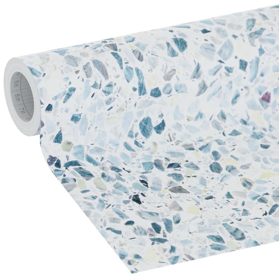 A roll of wallpaper with a terrazzo pattern featuring scattered blue, gray, and white stone-like shapes on a light background—perfect for pairing with easy corkboard placemats for a coordinated decor look.